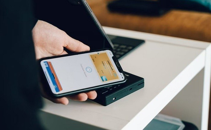 Лицо, использующее мобильные платежи NFC Apple Pay в своем цифровом кошельке.