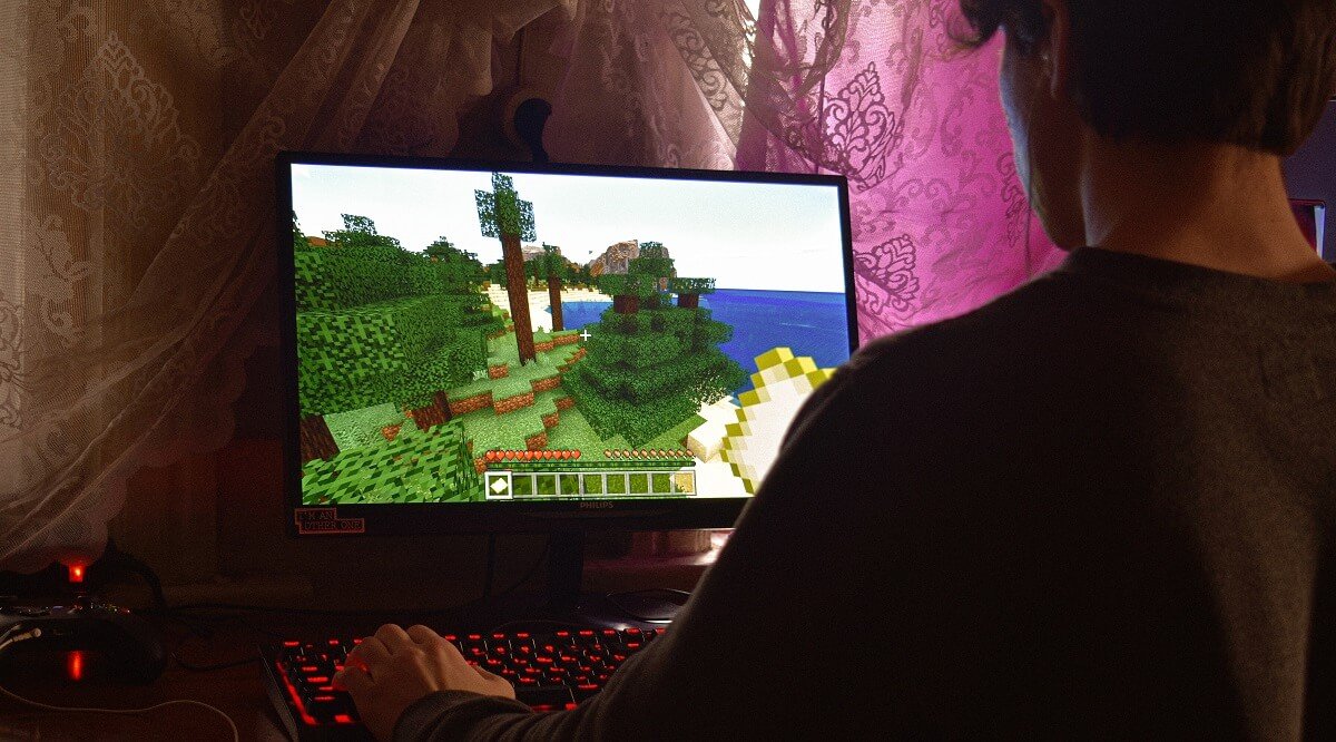 Геймер играет в Minecraft на игровом ПК.