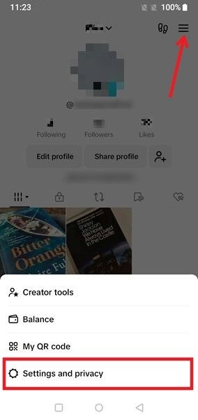 Выбор опции «Настройки и конфиденциальность» после нажатия на гамбургер-меню на странице профиля TikTok.