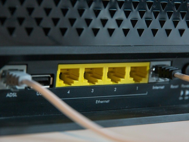 Крупный план беспроводного маршрутизатора: порты и кабели Ethernet.